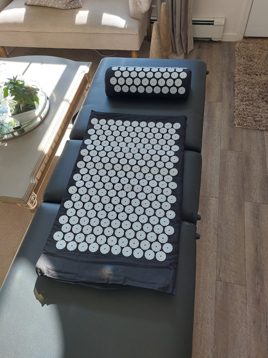 Customer photo of the acupressure mat and pillow laid out on a living room couch