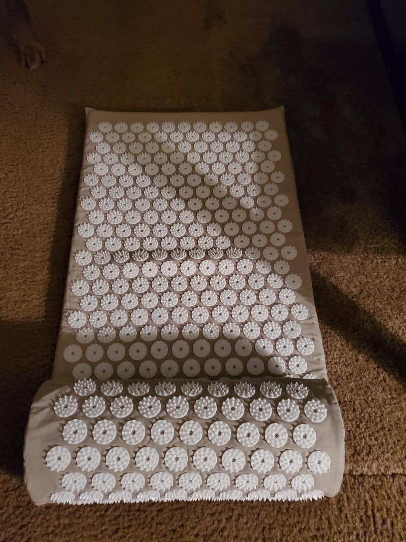 Customer photo of the beige acupressure mat and pillow on carpet