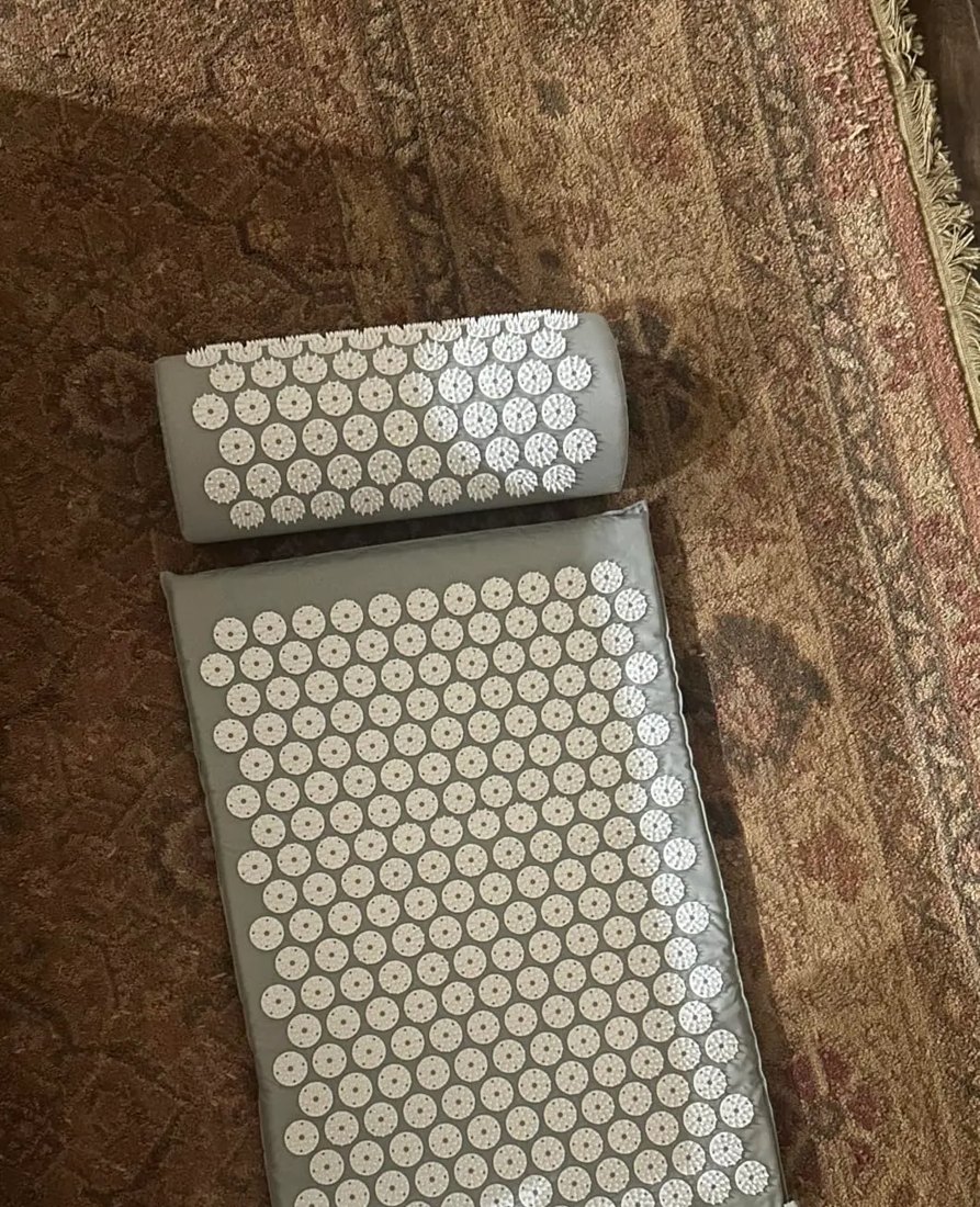 Customer photo of the grey mat and pillow set on a patterned rug