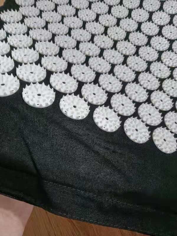 Close-up customer photo of the white spiked discs and stitching on the mat